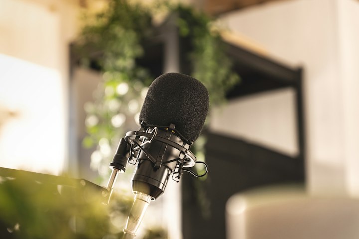 A studio microphone on a desk in soft light